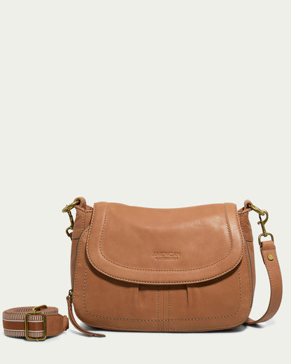 The Marino Crossbody with 2 Straps by American Leather Co. is crafted from premium tan leather, featuring a flap closure and embossed branding. Its functional design includes a detachable adjustable strap and gold-tone hardware, offering a simple, classic appearance.