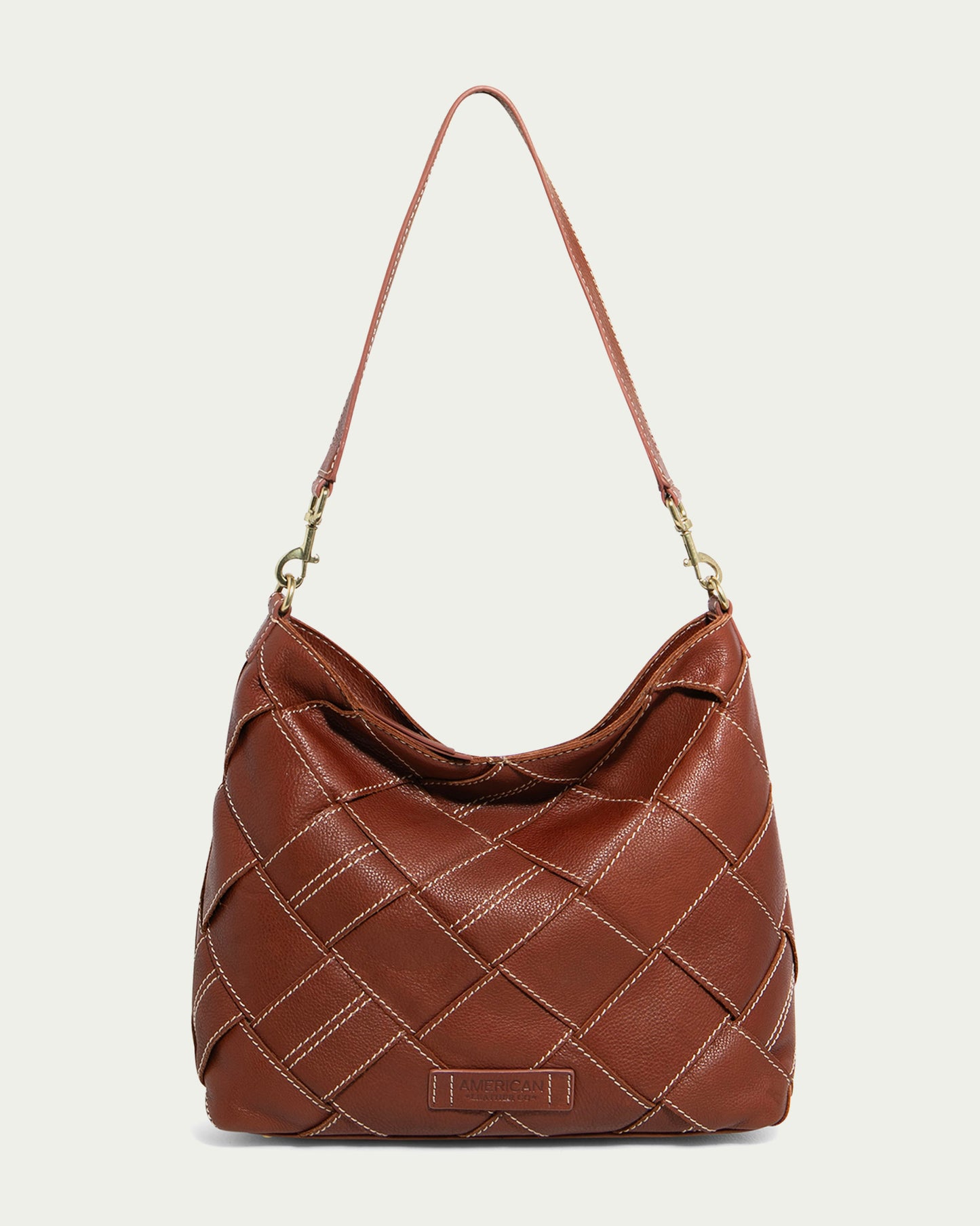 Discover the charm of the Mercer Woven Top Zip Hobo by American Leather Co. in brandy, featuring a quilted pattern and white stitching. The single strap boasts gold-tone hardware, adding elegance to this versatile piece.