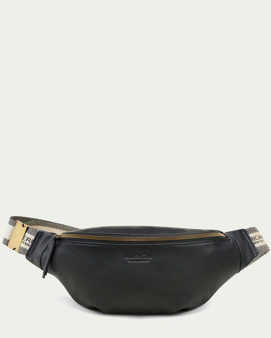 The Millwood Belt Bag by American Leather Co. is a black fanny pack featuring a gold zipper and "FRNC" written on a beige and black adjustable webbed strap. The front of the pouch is subtly branded with "American," making it ideal for hands-free living.