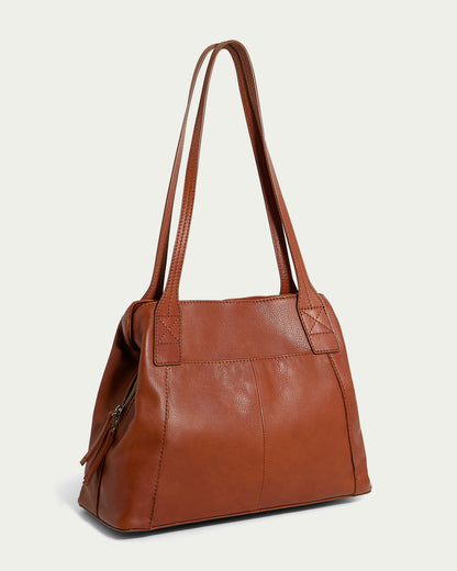 Introducing the Ada Triple Entry Tote by American Leather Co. - a stylish brown leather bag with a smooth finish and double handles. This chic tote features a structured, slightly trapezoidal shape, reinforced stitching at the handles' base, and a side view that reveals a zippered compartment with a convenient zipper pull for enhanced interior organization.