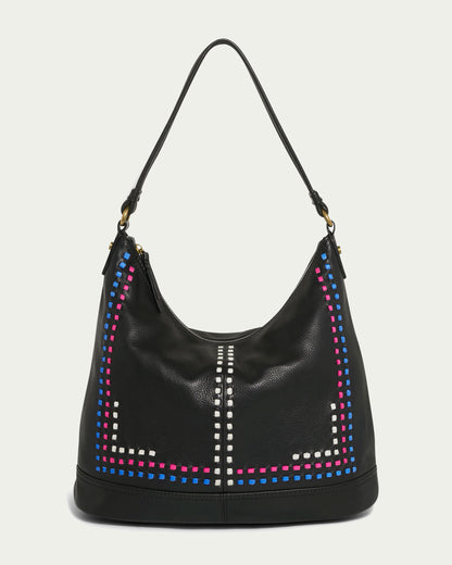 The Evelyn Hobo from American Leather Co. is a luxury black multi leather hobo bag featuring a single shoulder strap. It's crafted from genuine leather and adorned with colorful square studs in blue, pink, and white, arranged in a striking geometric pattern along the sides and center against an off-white background.