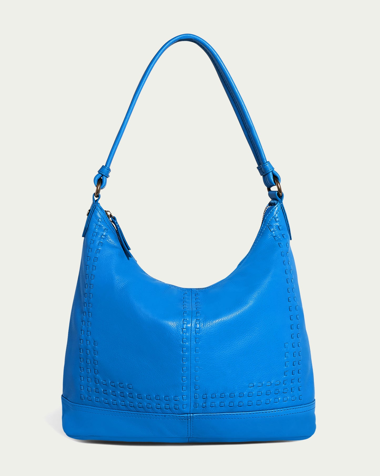 The elegant Evelyn Hobo by American Leather Co. comes in a stunning cerulean blue with a textured grid pattern along the edges. Featuring a single shoulder strap and top zip closure, this luxurious bag stands out beautifully against a simple, light background.