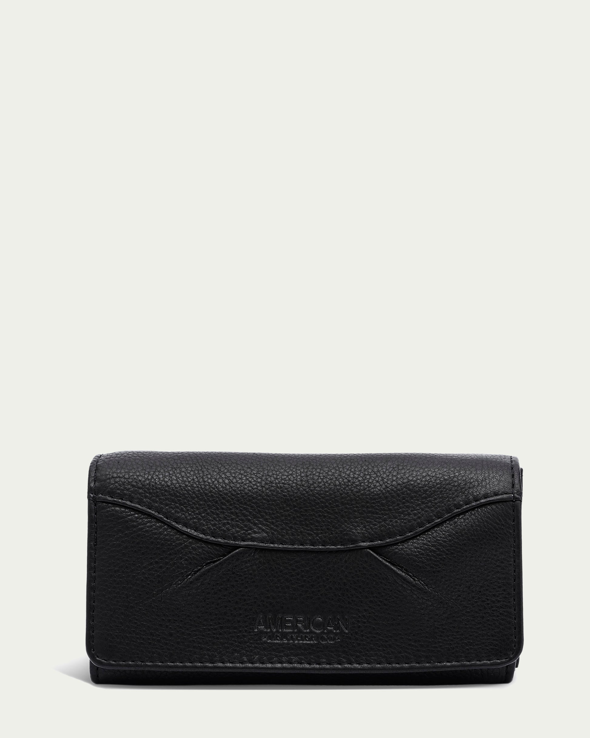 A black Hickory Bifold Wallet from American Leather Co. is closed and shown against a plain light-colored background. The wallet boasts a simple design with subtle stitching and slight texture. The word "AMERICAN" is embossed on the lower front, highlighting its genuine leather quality.