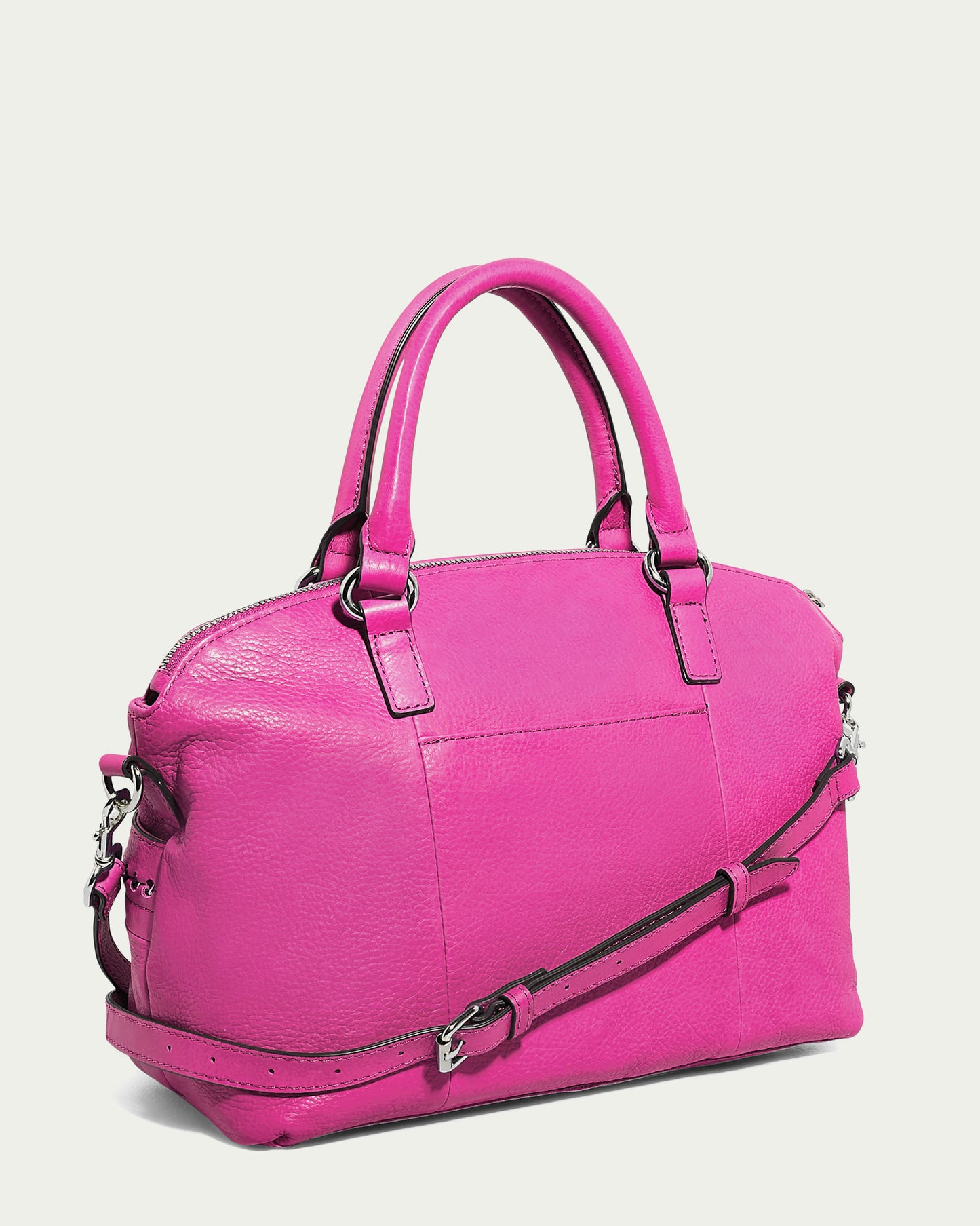 The Janssen Dome Satchel by American Leather Co. is a striking pink leather handbag featuring dual handles, a detachable shoulder strap, silver hardware, and a textured surface. Ideal for everyday use, it makes an elegant statement against a plain white background.