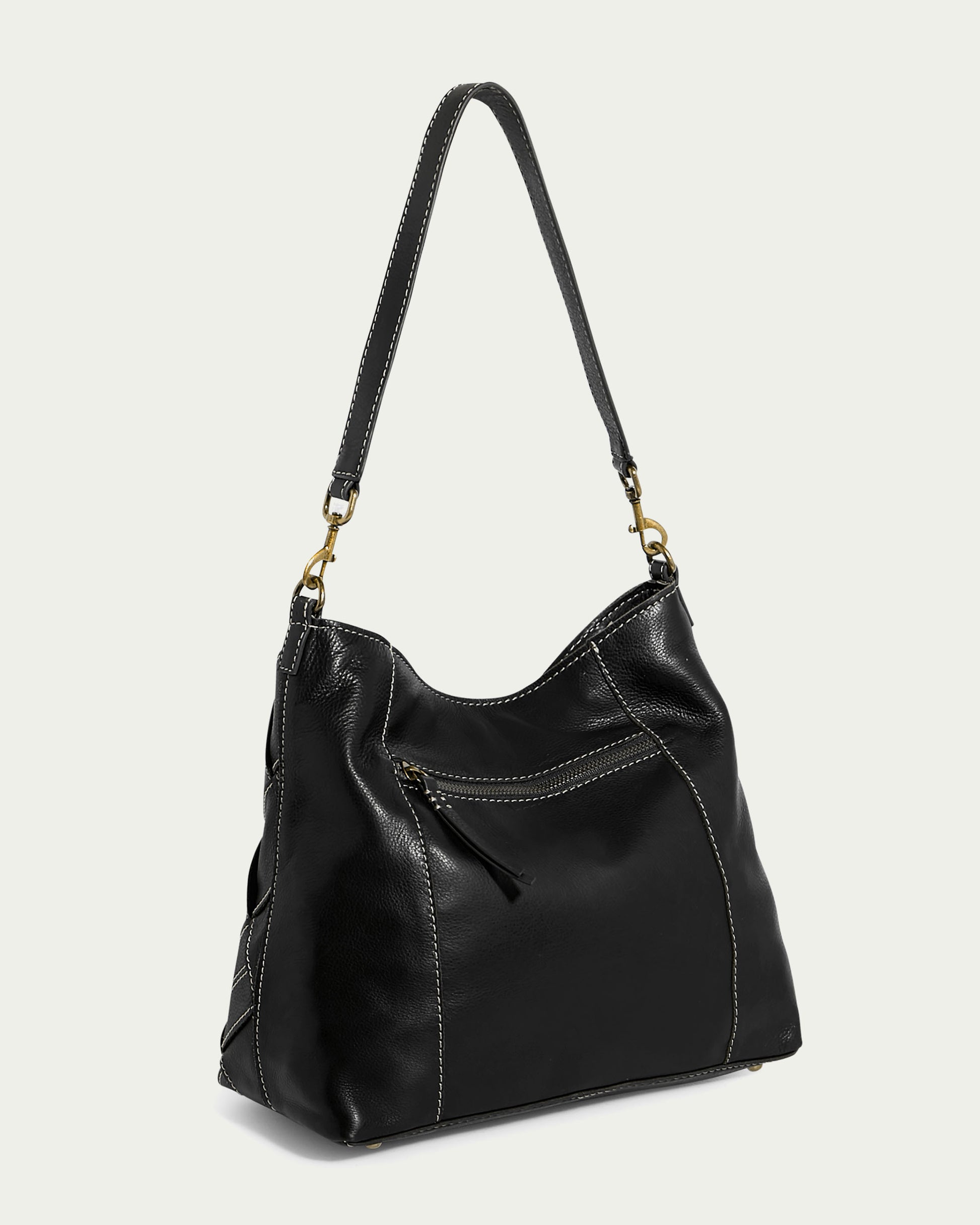 The image displays the American Leather Co.'s Mercer Shoulder, a black leather handbag with a detachable shoulder strap. It is adorned with decorative stitching and includes a front zippered pocket. The bag is artfully positioned at an angle against a neutral background.