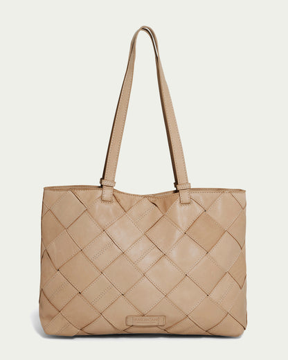 A Macadamia-colored Mercer Woven Tote from American Leather Co., crafted in quilted genuine leather, is set against a plain background. The handbag showcases a grid pattern akin to hand-woven panels and features double shoulder straps with a subtle rectangular brand label near the base.