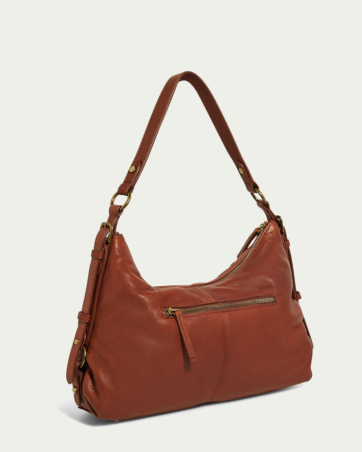 A stylish Thayer Perfect Hobo from American Leather Co. in genuine brown leather with a single strap and a front zipper pocket. The leather purse features metal hardware and a slightly slouchy design, offering a casual yet sophisticated look. The strap is affixed to the bag with metal rings, set against a plain light green background.