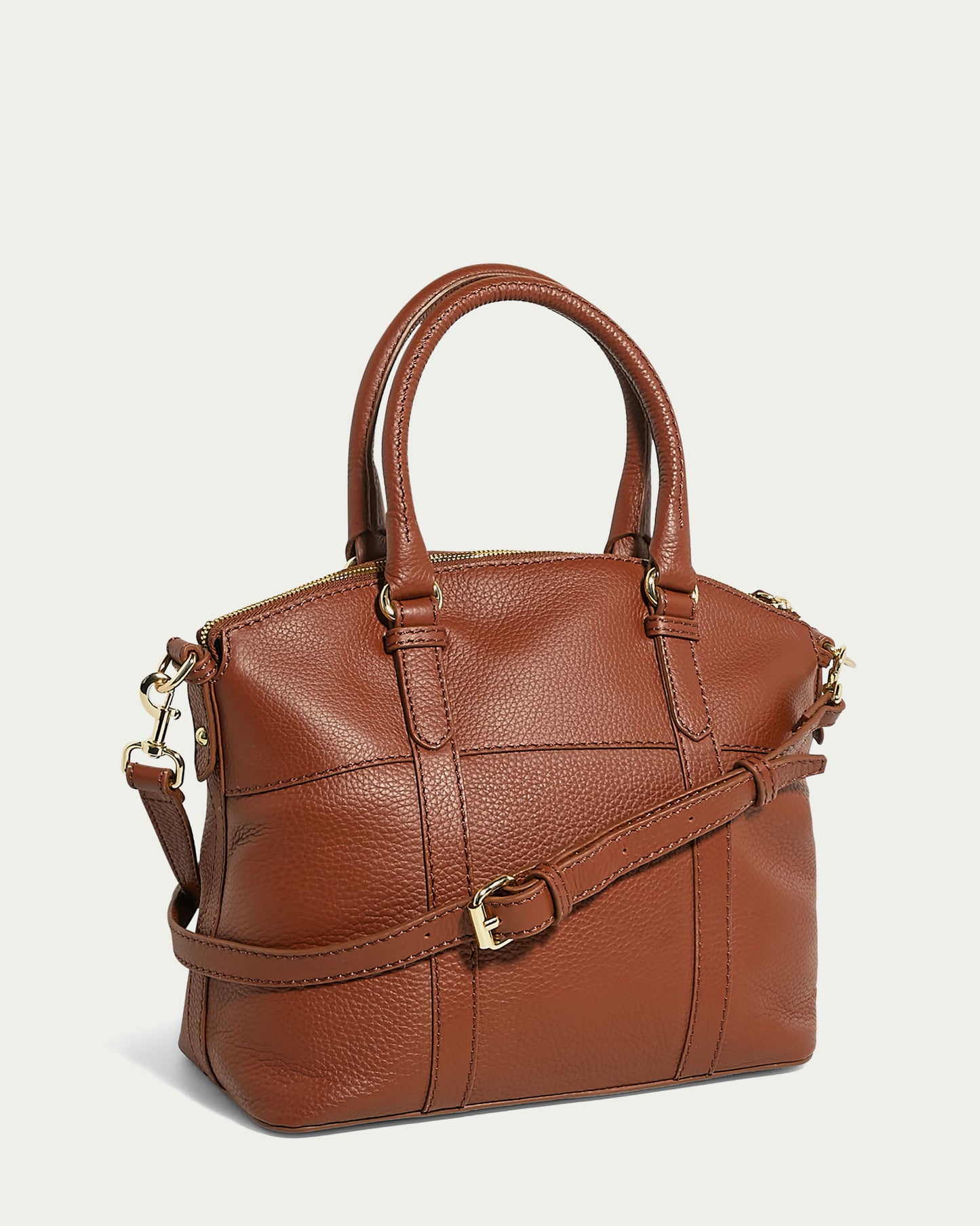 The Vona Convertible Dome Satchel by American Leather Co. is a genuine leather brown handbag with a pebbled texture and gold-tone hardware. This sleek and structured Forever Pebble leather bag features two handles, a detachable shoulder strap with an adjustable buckle, and a top zipper closure.