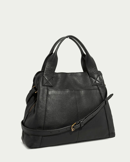 The Ada Triple Entry Satchel by American Leather Co. is a black leather structured bag with textured surface, gold-toned hardware, two short handles, and a detachable adjustable crossbody strap. It's crafted from genuine American leather and shown on a plain light gray background.