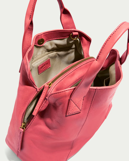 The Ada Triple Entry Satchel by American Leather Co. is a pink genuine leather tote with a structured design, featuring dual handles, a zipper closure, an open view of its beige interior, a small interior pocket, and a visible brand label.