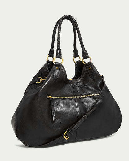 The Blair Convertible Tote by American Leather Co. is crafted from genuine woven leather in sleek black. It includes gold hardware, like buckles and a front zipper pocket, with braided handles and a structured design that beautifully contrasts against a light gray background.