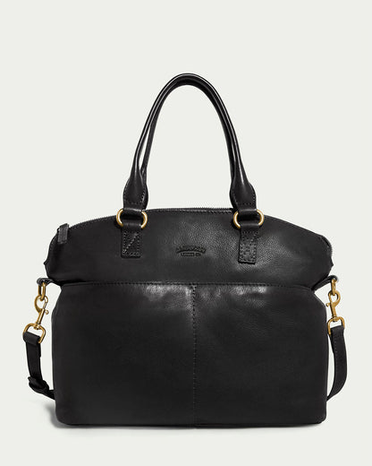 The Carrie Dome Satchel by American Leather Co. is a black leather handbag with dual handles, a detachable crossbody strap, gold-tone hardware, and features a curved zippered top and subtle front stitched detailing.