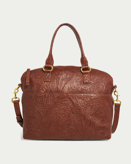 The Carrie Dome Satchel by American Leather Co. is crafted from genuine brown American leather with an embossed floral pattern. It offers versatile wearing options with two short handles and an adjustable crossbody strap featuring gold clasps.