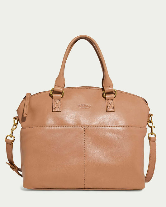 The Carrie Dome Satchel by American Leather Co. in Nutmeg is a leather bag featuring two handles, an adjustable crossbody strap, gold hardware, and a subtle embossed logo. It offers a smooth texture and exterior pockets for added functionality.