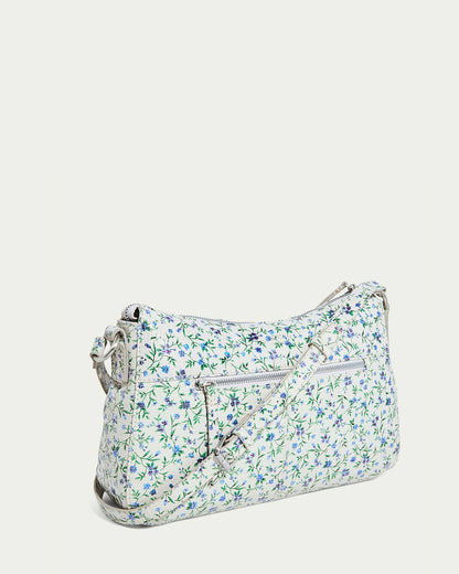 The Holton Crossbody by American Leather Co. is a white glove leather shoulder bag adorned with a blue and green floral pattern, featuring a front zip pocket and an adjustable strap against a plain background for elegance.