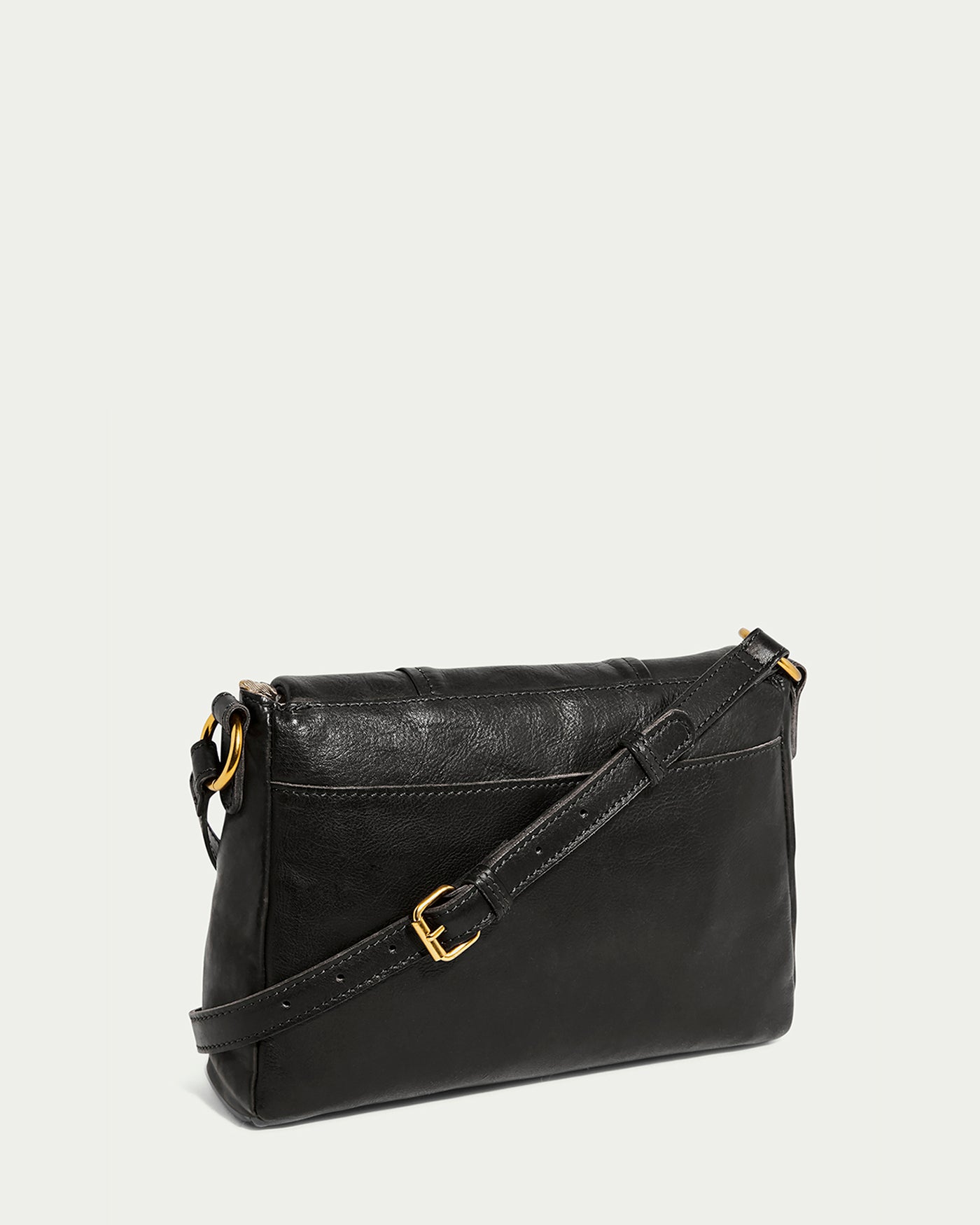 The Lee Double Entry Crossbody by American Leather Co. is a sleek black leather bag with a long adjustable strap and gold buckle accents against a white background, featuring visible stitching and a zippered top closure for an elegant appeal.