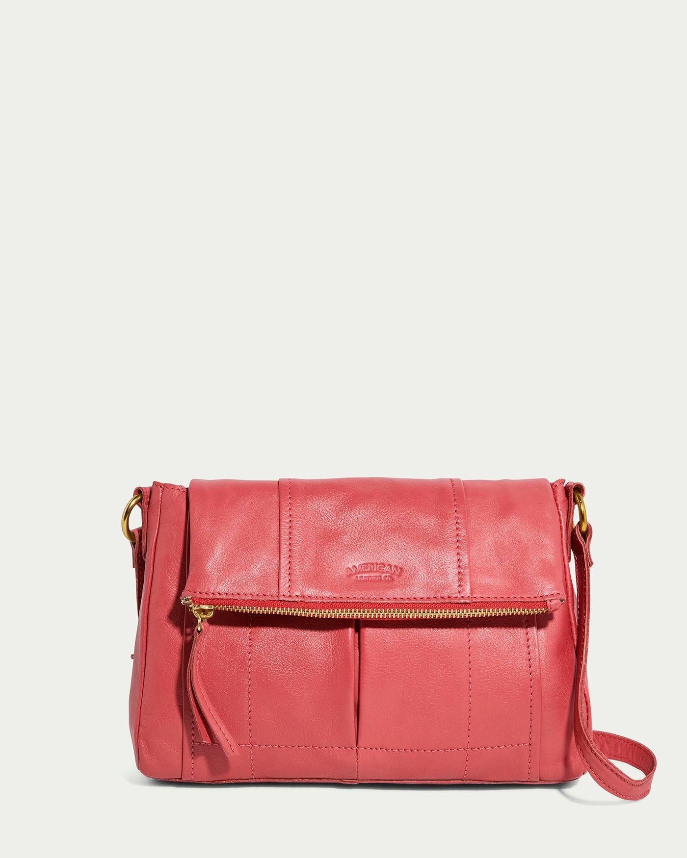 The Lee Double Entry Crossbody by American Leather Co. is a French Rose leather shoulder bag with a flap closure and front zipper pocket. Featuring a gold hardware-embellished strap, it has a chic textured finish ideal for any occasion.