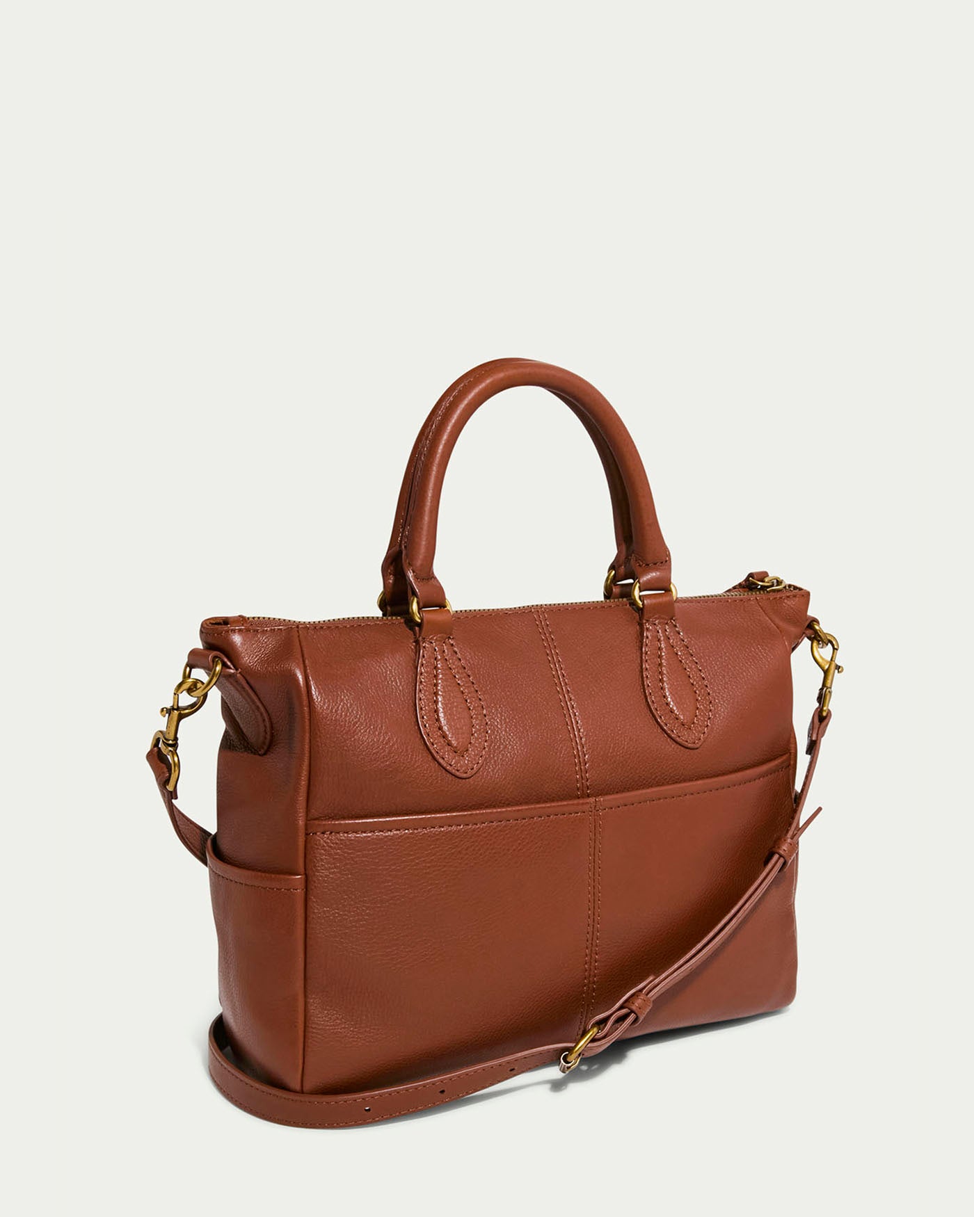 Introducing the Madison Satchel by American Leather Co.: This elegant brown glove leather handbag features dual top handles, a detachable adjustable shoulder strap, gold-tone hardware, hand-woven detailing, and a zipper closure for a smooth and simple design.