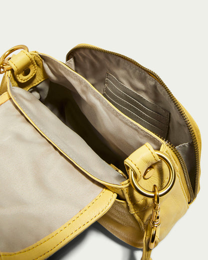 The Marino Mini Crossbody by American Leather Co. is crafted in yellow glove leather with a zippered opening, beige fabric lining, inner zip pocket, card slots, gold hardware, and an adjustable chain strap for versatility.