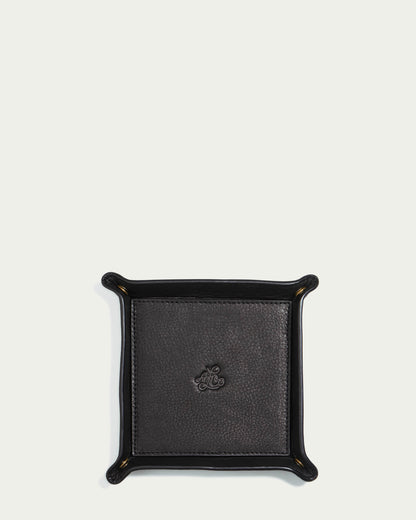 The Manchester Leather Tray by American Leather Co. is a black leather valet tray with raised edges, crafted from genuine leather, featuring a subtle embossed logo in the center on a light background.