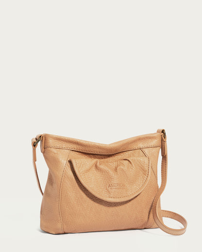 The Reed Crossbody by American Leather Co. is made from glove leather and showcases a tan hue with an embossed texture on the flap pocket. The discreet 'AMERICAN LEATHER CO.' logo provides an elegant detail, and the adjustable crossbody strap allows for versatile use and stylish simplicity.