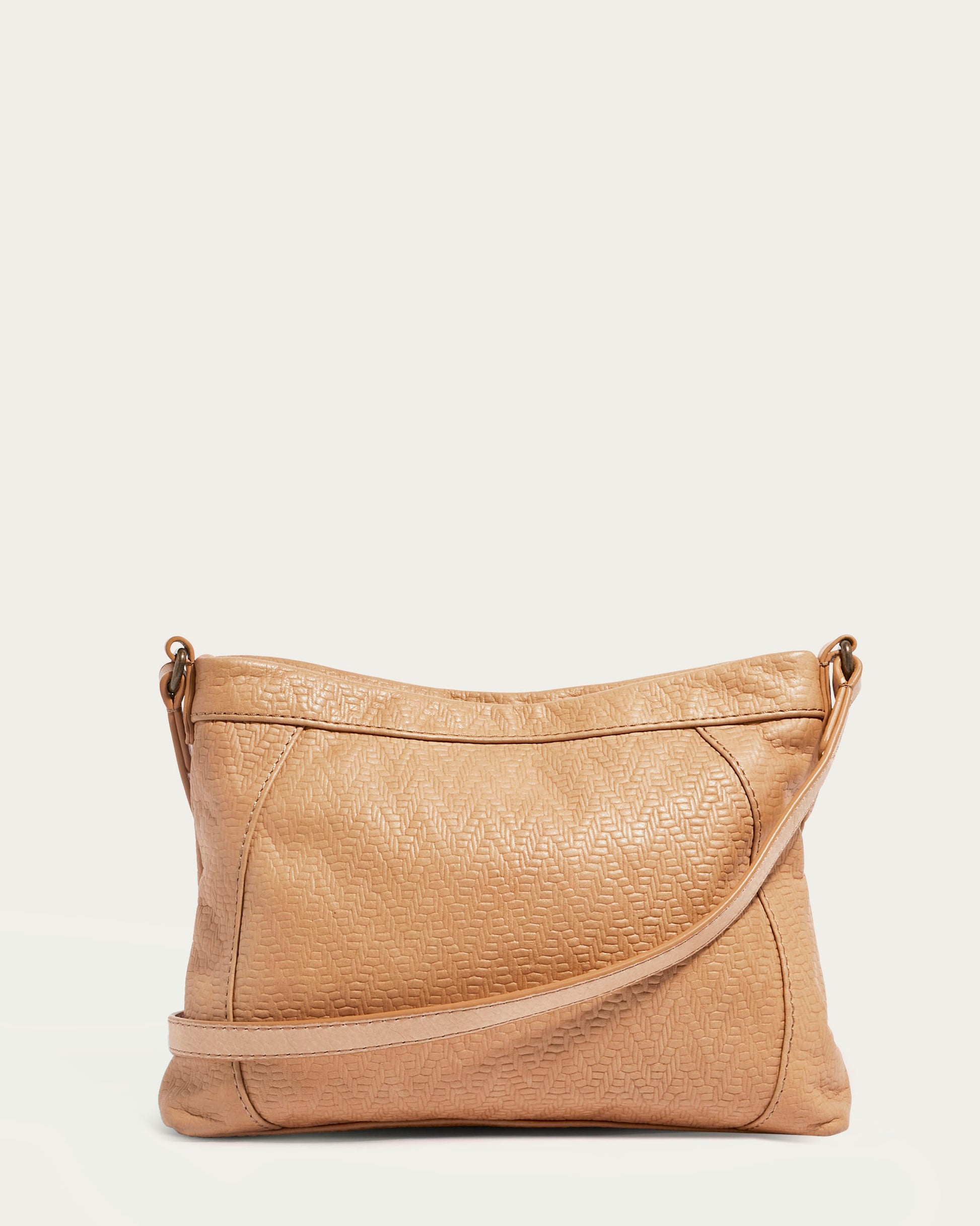 The Reed Crossbody handbag by American Leather Co. is expertly crafted from luxurious tan glove leather, featuring a subtle textured pattern and a versatile crossbody strap. It boasts a zippered top and is elegantly displayed against a plain white background.