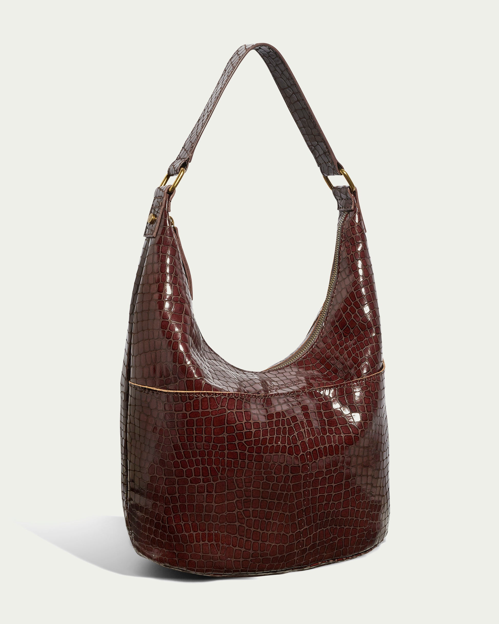 Displayed against a light background, the Carrie Hobo from American Leather Co. is a glossy, brown leather hobo bag featuring a crocodile pattern and a single shoulder strap, crafted from genuine American leather.