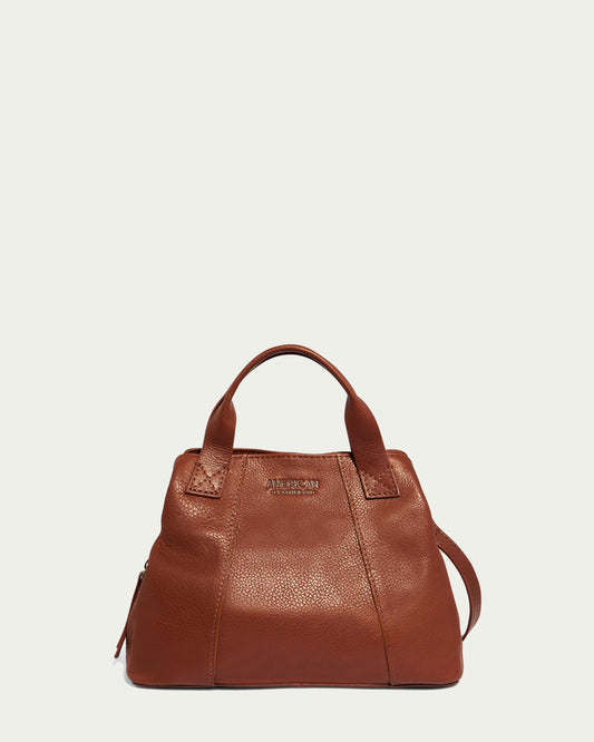 The Ada Triple Entry Crossbody from American Leather Co. is displayed against a plain light background. This brown leather bag features a textured surface, two short handles, and a long shoulder strap. The front proudly showcases the embossed brand logo and name.