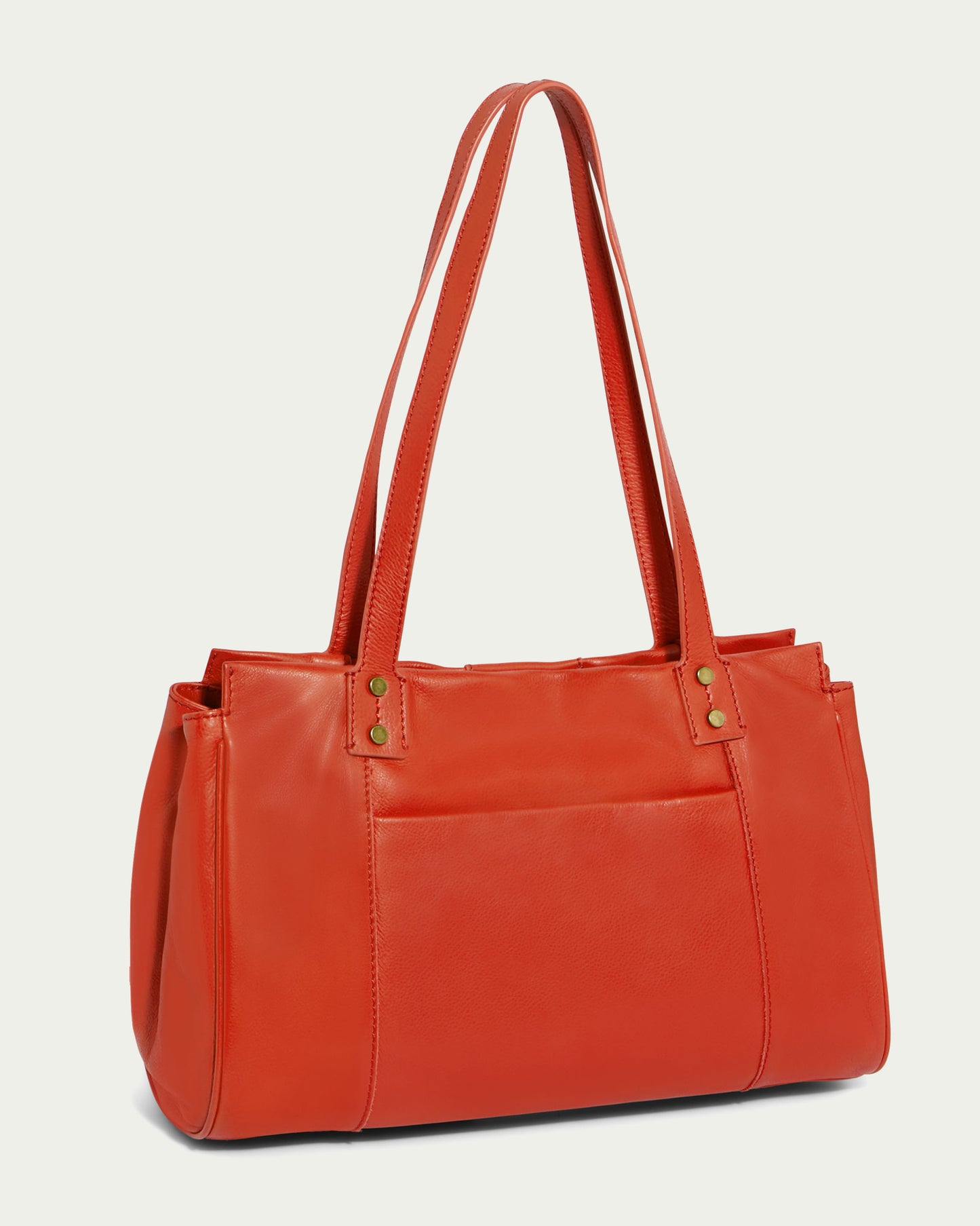 The Layton Satchel by American Leather Co. is a vibrant orange leather tote bag featuring long, slim handles and a center zipper compartment. This rectangular-shaped bag includes multiple interior pockets, a front pocket, and is accented with subtle gold snaps at the base of the handles. Its clean design provides a modern and elegant look.