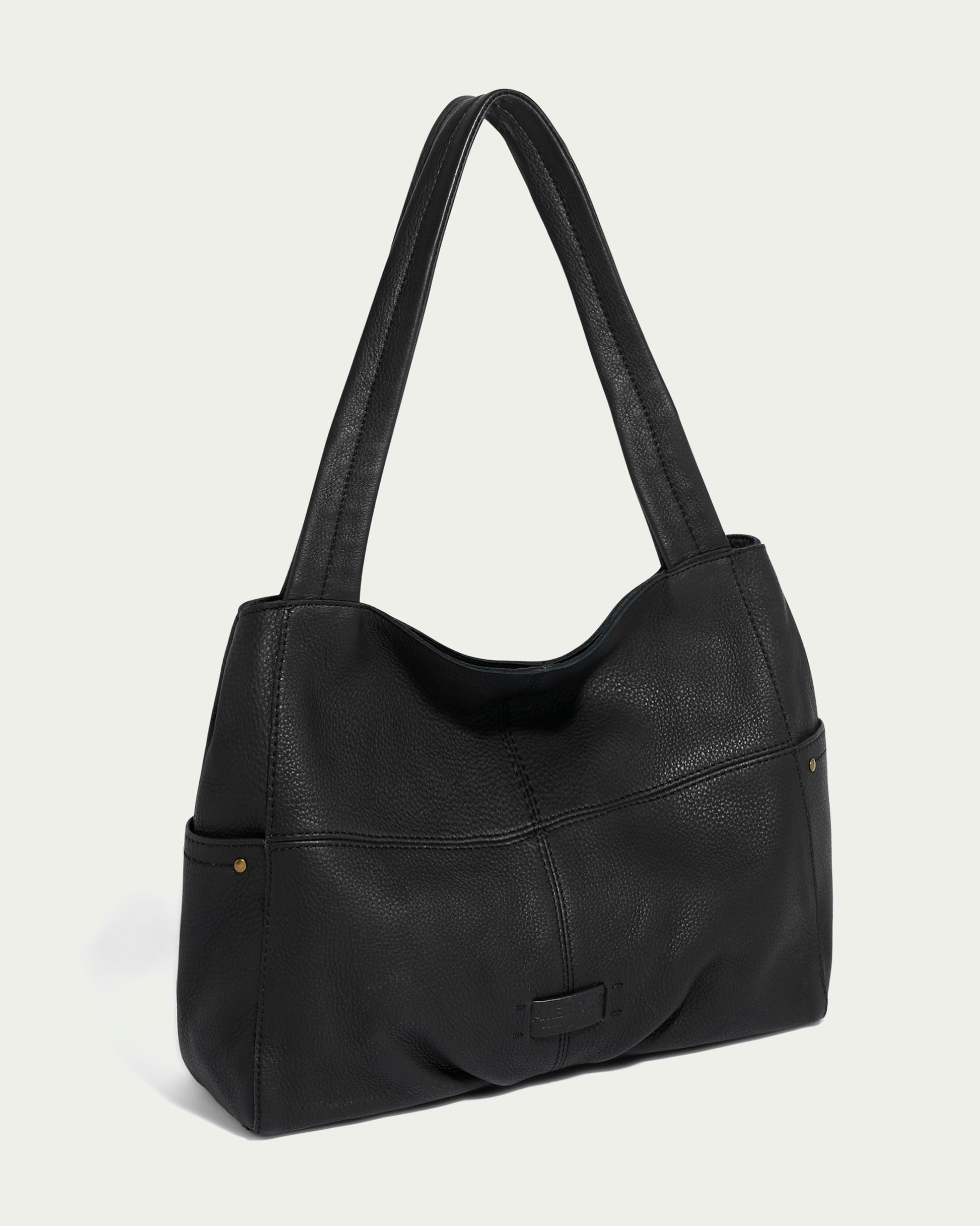 The Virginia Tote from American Leather Co. is made from luxe black calf leather and comes with dual shoulder straps. It features a textured surface with subtle stitching, offering a spacious interior and a sleek, minimalist design perfect for everyday use.