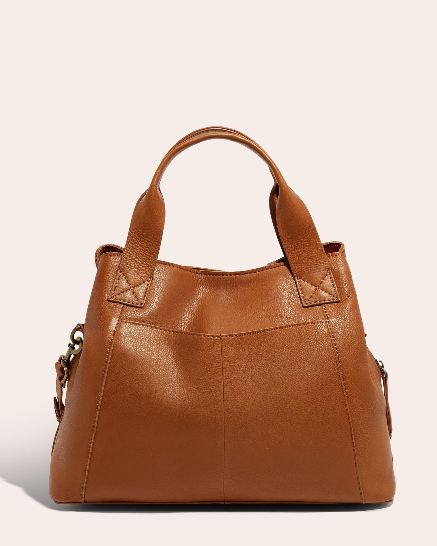 Introducing the Ada Triple Entry Satchel by American Leather Co., a stylish tan leather handbag crafted from Genuine American Leather with a smooth finish. It features double straps attached to the top and a subtle stitch design on the front. The bag has a slightly structured shape and side panels that provide additional depth.