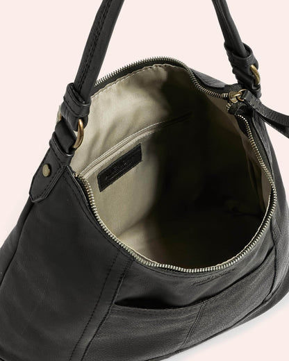 The Hudson Hobo by American Leather Co. is a black leather shoulder bag with a light beige interior lining, shown with its zipper open to reveal an inner zippered pocket. Crafted from genuine American leather, the bag features sturdy black handles adorned with gold-tone antiqued hardware.